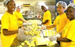 Youth employees scooping cookie dough in the bakery.